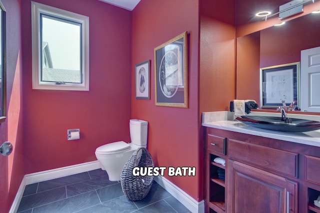 bathroom featuring vanity, tile patterned floors, and toilet