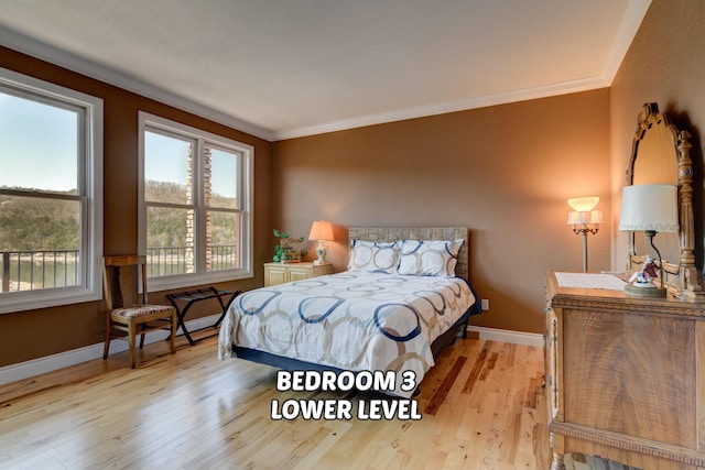 bedroom featuring crown molding and light hardwood / wood-style floors