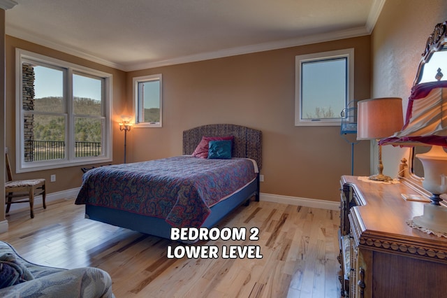 bedroom featuring crown molding and light hardwood / wood-style floors