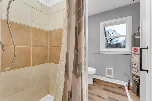 bathroom featuring hardwood / wood-style flooring, toilet, water heater, and a shower with curtain