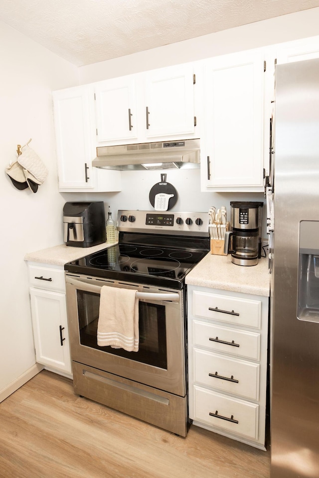 kitchen featuring appliances with stainless steel finishes, white cabinets, and light hardwood / wood-style flooring