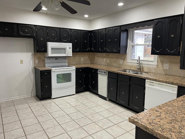 kitchen featuring light stone countertops, white appliances, tasteful backsplash, and a sink