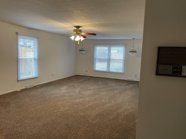 unfurnished room featuring ceiling fan, carpet flooring, a wall mounted air conditioner, and a textured ceiling