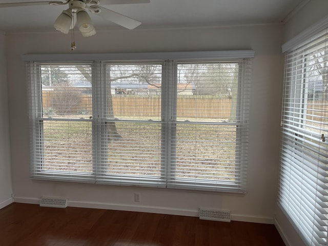 interior space featuring a ceiling fan, wood finished floors, visible vents, and baseboards