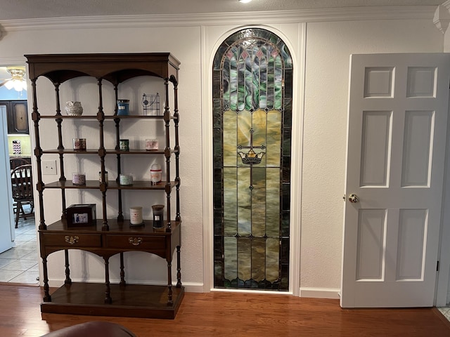 interior space with baseboards, ornamental molding, and wood finished floors