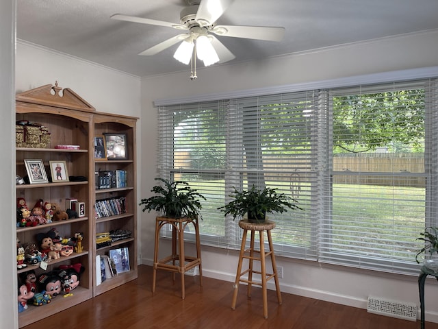 sitting room featuring dark wood finished floors, visible vents, ornamental molding, ceiling fan, and baseboards