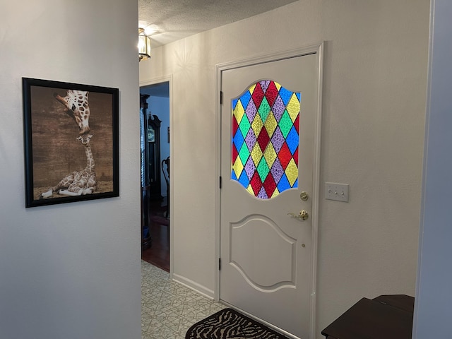 interior space with a textured ceiling and light floors