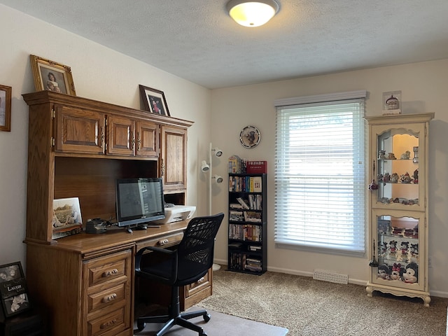 office area with baseboards, a textured ceiling, and light colored carpet