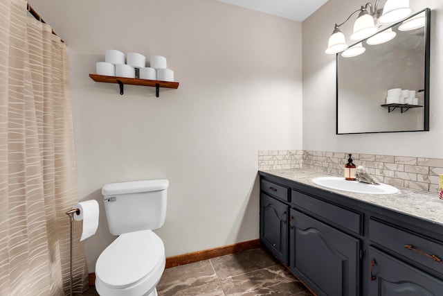 bathroom featuring vanity, toilet, and decorative backsplash