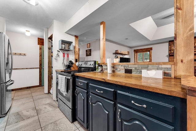 kitchen featuring wood counters, light tile patterned floors, and stainless steel appliances