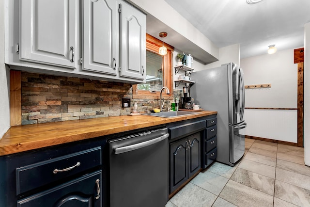 kitchen featuring sink, butcher block countertops, white cabinetry, stainless steel appliances, and decorative backsplash