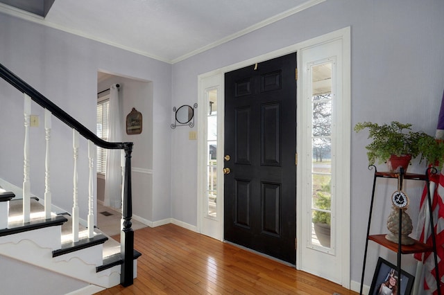 entryway with wood-type flooring and crown molding