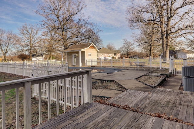 wooden terrace with an outbuilding and a patio