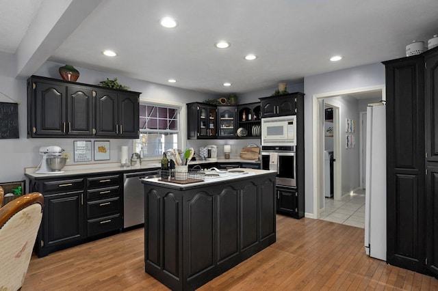 kitchen with light wood-type flooring, stainless steel appliances, and a kitchen island