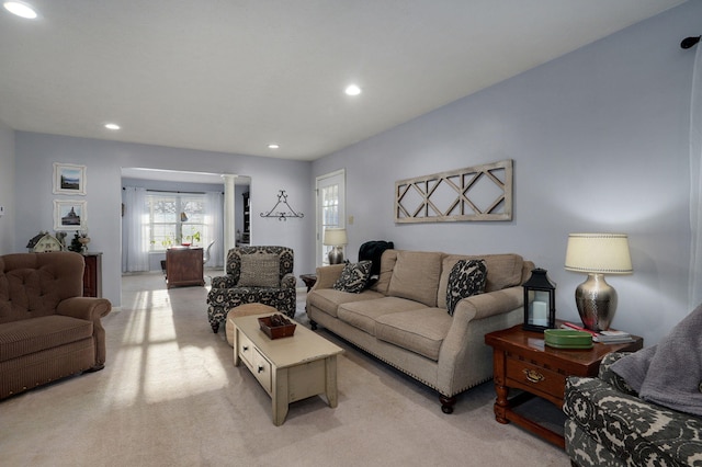 carpeted living room with decorative columns