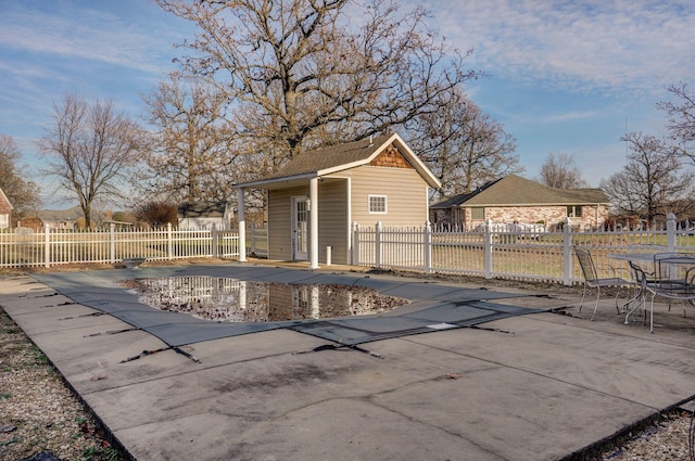 view of swimming pool featuring a patio and an outbuilding