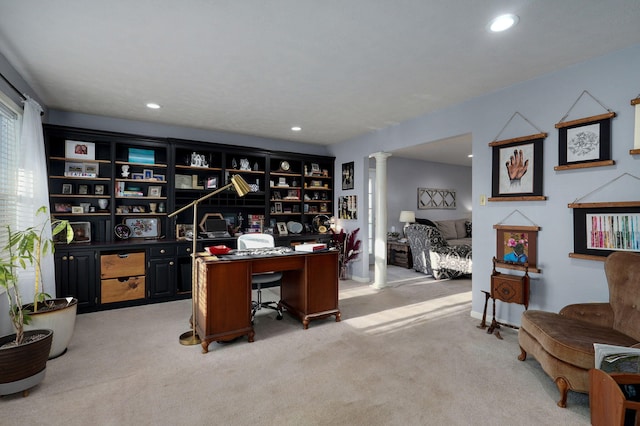 home office with ornate columns and light colored carpet