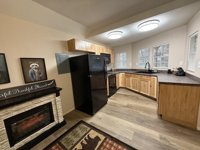 kitchen featuring a fireplace, sink, light hardwood / wood-style floors, black appliances, and light brown cabinets