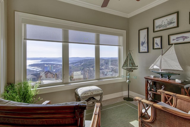 sitting room featuring crown molding, ceiling fan, and a mountain view