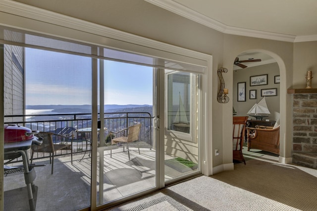 doorway with crown molding, ceiling fan, a mountain view, and carpet floors