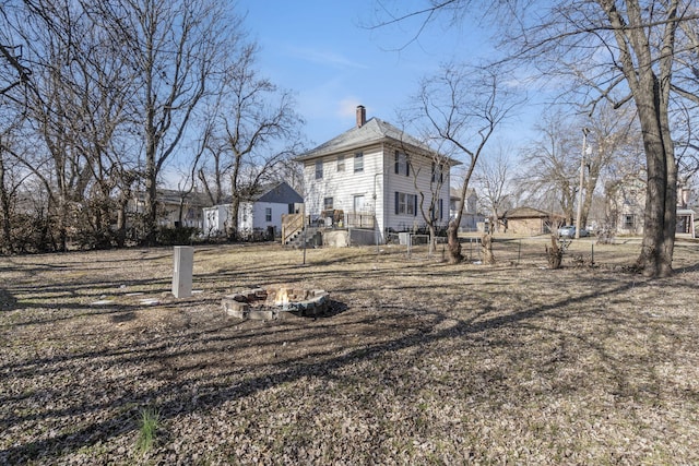 back of property with an outdoor fire pit