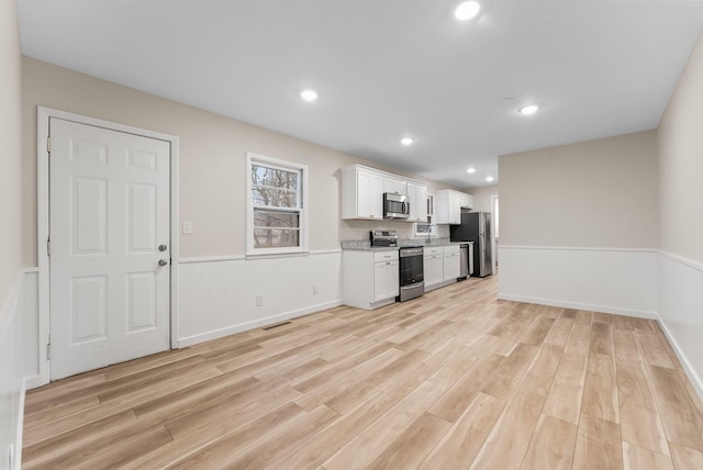 kitchen featuring white cabinetry, light hardwood / wood-style flooring, and appliances with stainless steel finishes