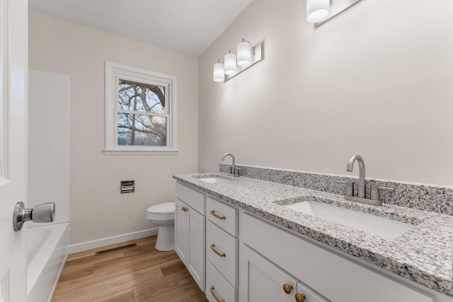 bathroom featuring vanity, hardwood / wood-style floors, and toilet