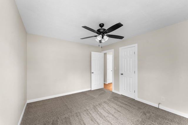 empty room with ceiling fan and carpet flooring