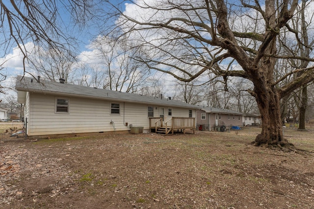 rear view of property featuring a wooden deck and central AC unit