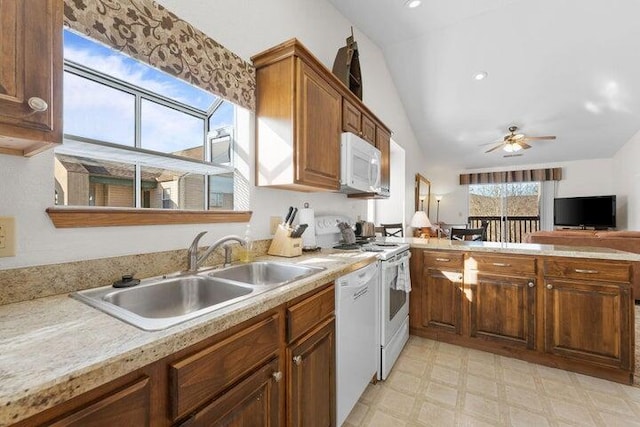 kitchen featuring vaulted ceiling, white appliances, ceiling fan, and sink