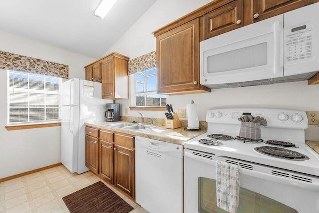 kitchen featuring vaulted ceiling, white appliances, and sink