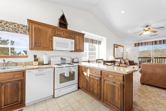 kitchen featuring sink, vaulted ceiling, ceiling fan, kitchen peninsula, and white appliances