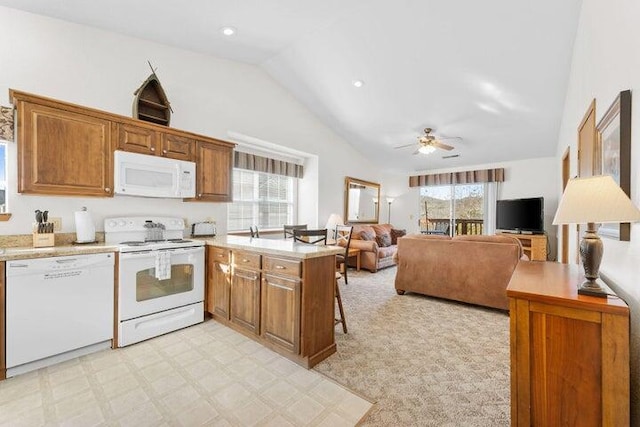 kitchen featuring a kitchen bar, white appliances, high vaulted ceiling, kitchen peninsula, and ceiling fan