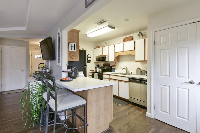 kitchen with sink, dark hardwood / wood-style floors, white cabinets, and appliances with stainless steel finishes