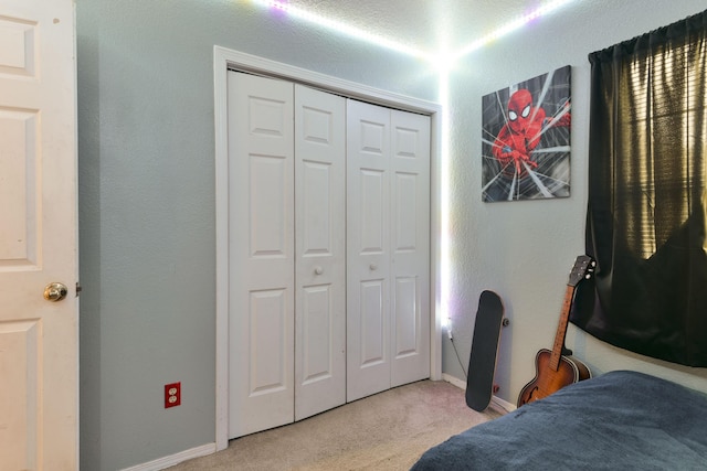 bedroom with light colored carpet and a closet