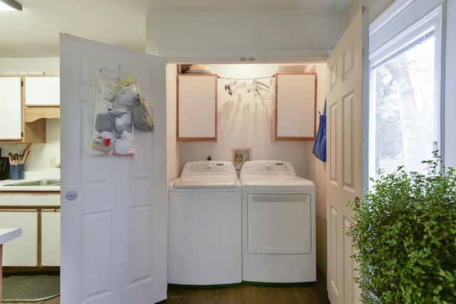 laundry area with separate washer and dryer, sink, dark hardwood / wood-style flooring, and cabinets