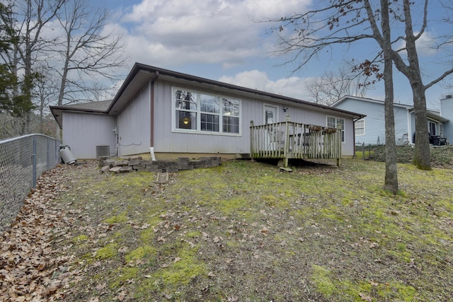 back of property with a wooden deck, a lawn, and central air condition unit