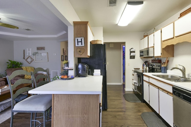 kitchen with white cabinetry, sink, dark wood-type flooring, and black appliances