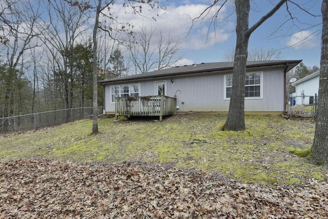 rear view of property with a deck and a lawn