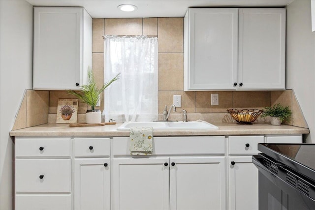 kitchen with white cabinetry, sink, and backsplash