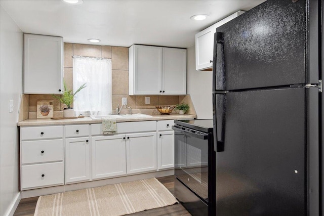 kitchen featuring sink, white cabinetry, tasteful backsplash, dark hardwood / wood-style flooring, and black appliances