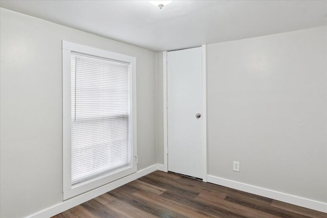 empty room with dark hardwood / wood-style flooring