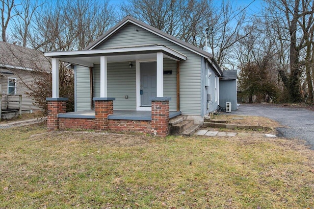 bungalow featuring covered porch and a front yard