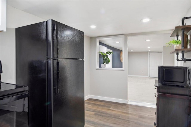 kitchen featuring hardwood / wood-style flooring and black appliances