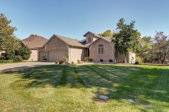 view of front of property with driveway, brick siding, an attached garage, and a front yard