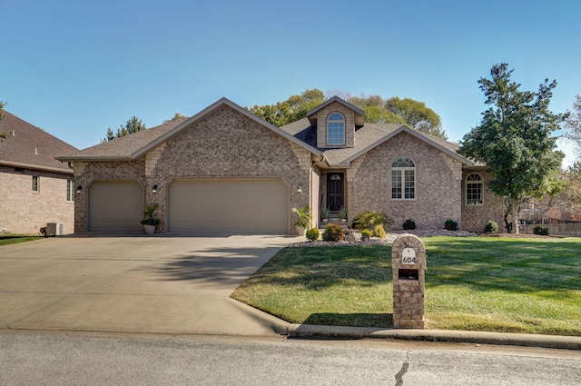 view of front of house featuring brick siding, roof with shingles, a front yard, a garage, and driveway