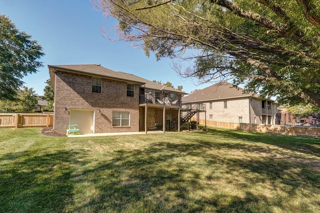 back of house featuring a lawn and a deck