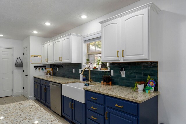 kitchen featuring blue cabinets, sink, dishwasher, light stone countertops, and white cabinets