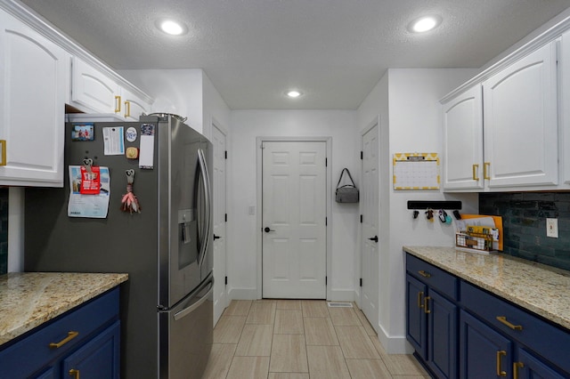 kitchen featuring stainless steel fridge with ice dispenser, white cabinets, and blue cabinets