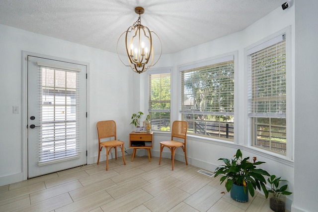 sitting room featuring a wealth of natural light, a textured ceiling, and a chandelier